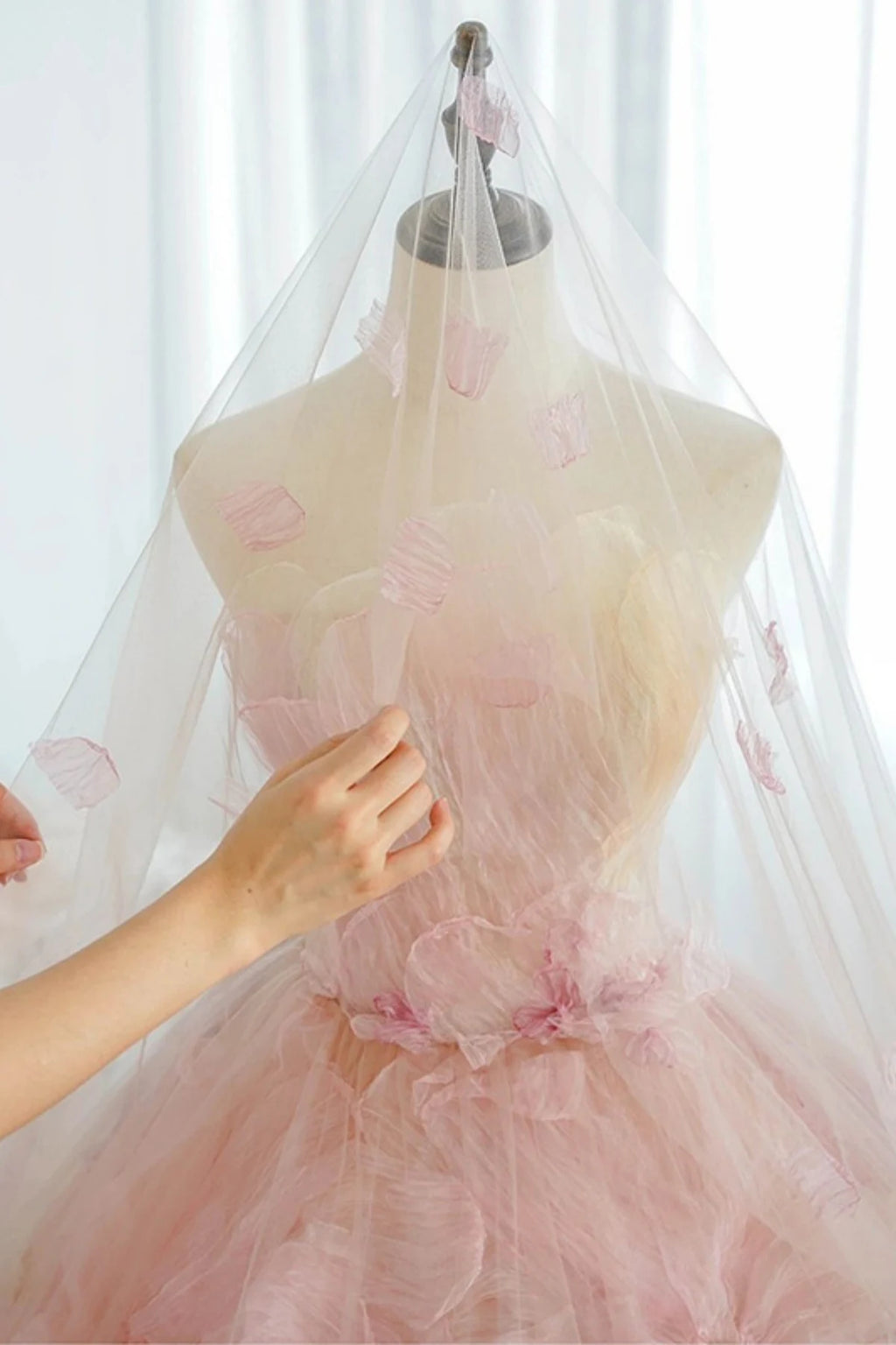 display of a luxury pink and multi-colored organza flower wedding dress