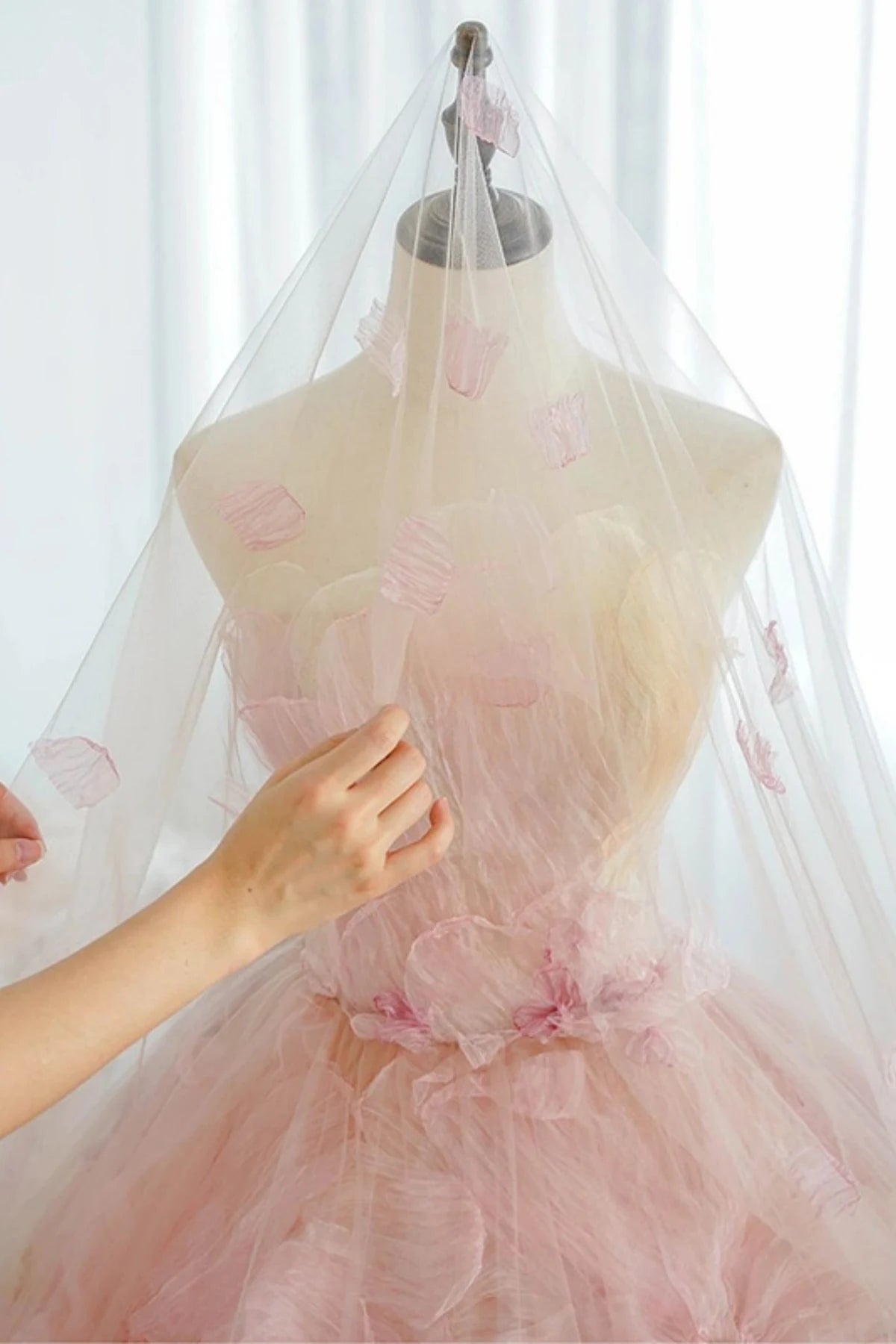 display of a luxury pink and multi-colored organza flower wedding dress