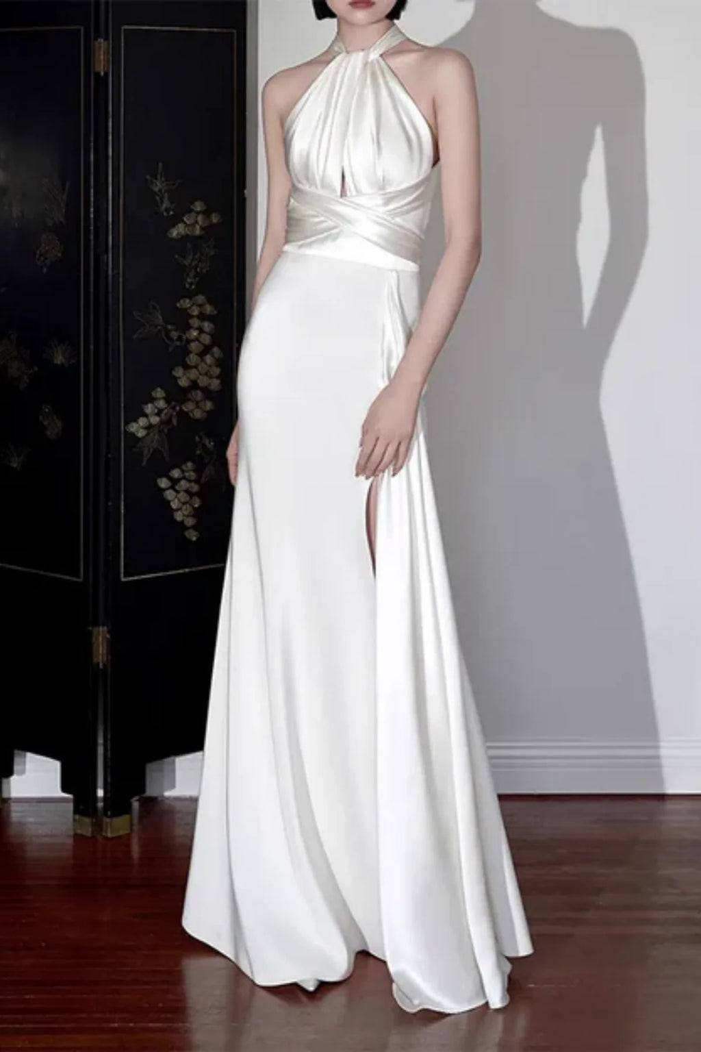 Halter neck satin wedding dress with open back, waist tie detail, and thigh high slit
