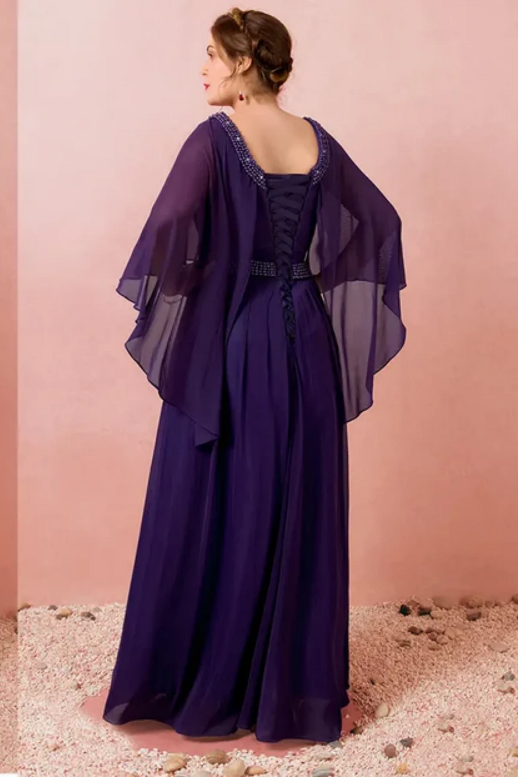 Back view of navy blue mother of the bride dress with lace-up corset back, beaded neckline, and layered chiffon cape sleeves