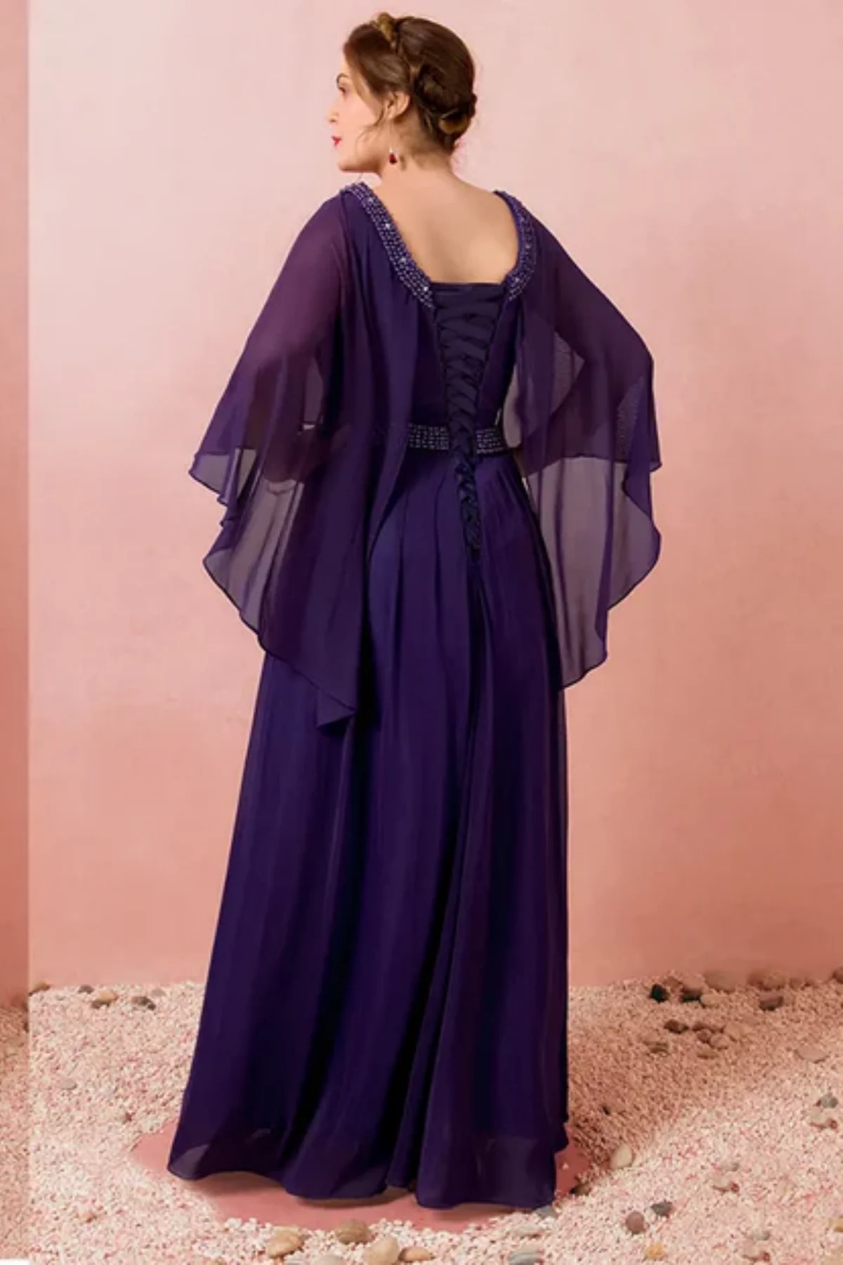 Back view of navy blue mother of the bride dress with lace-up corset back, beaded neckline, and layered chiffon cape sleeves