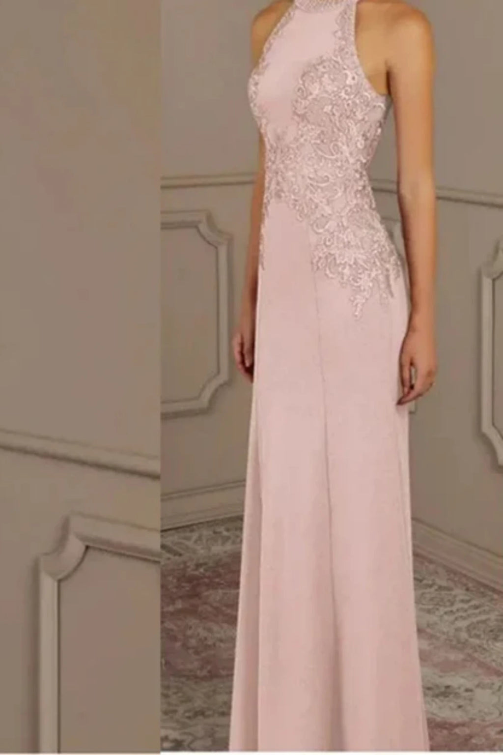 side full-length view of a pastel pink mother of the groom dress featuring a beaded halter neckline, lace appliqués on the bodice, and a fitted mermaid skirt on a mannequin