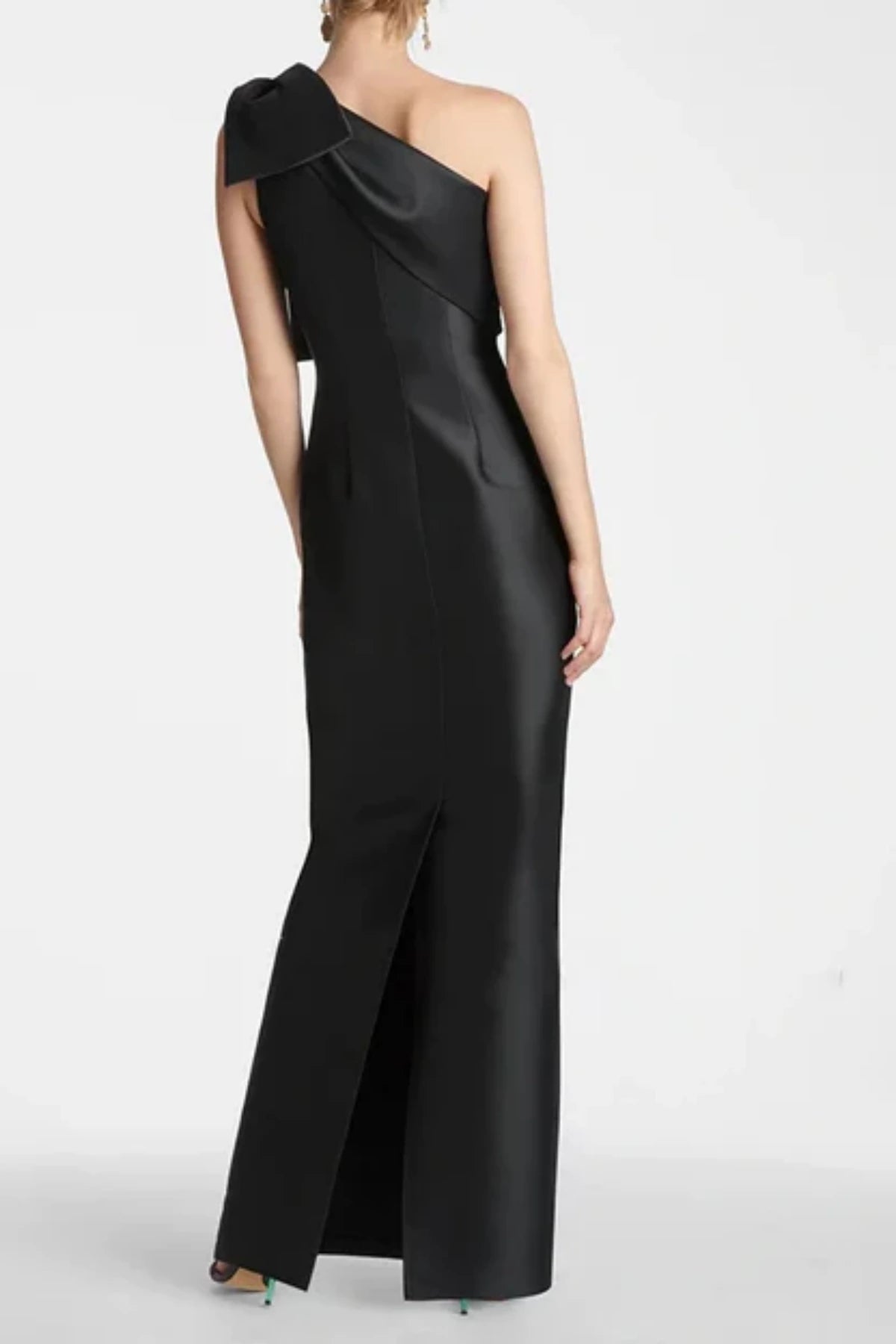 Full back view of a black satin formal evening gown, featuring a tailored column silhouette with a subtle center back slit at the hemline