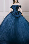 Front view of an off-the-shoulder midnight navy blue bridal ballgown featuring a structured satin bodice and a voluminous tulle skirt with a large ruched fabric rosette at the waist