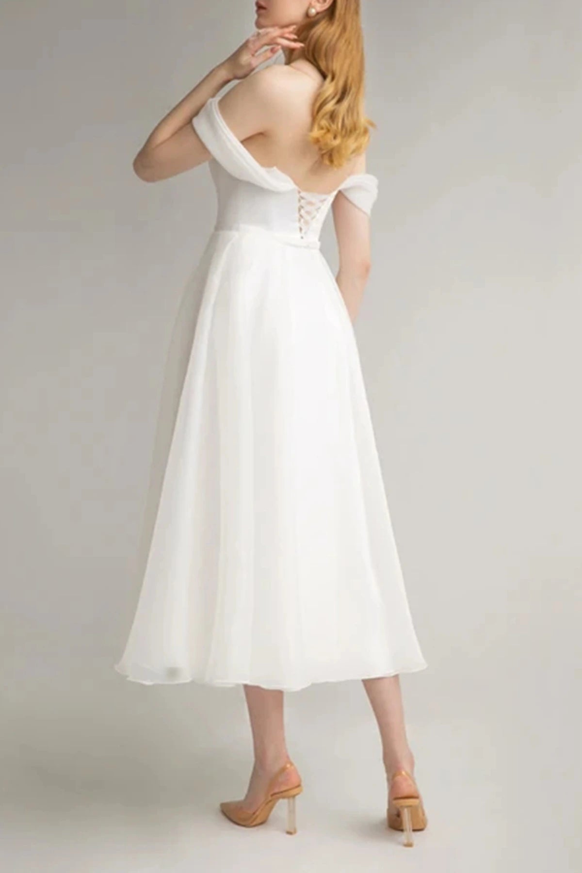 Back view of an off-the-shoulder tea-length wedding dress showcasing the adjustable lace-up corset back design