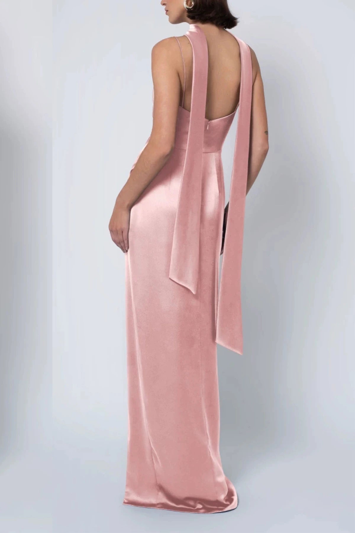a dusty pink satin bridesmaid gown showing an open back, delicate spaghetti straps, and long trailing neck scarf ties