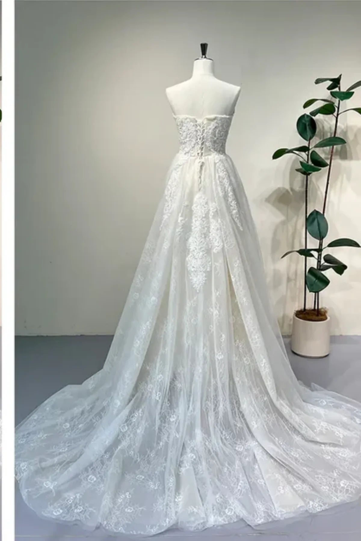 Back view of lace A-line convertible wedding dress with chapel train and corset lace-up back