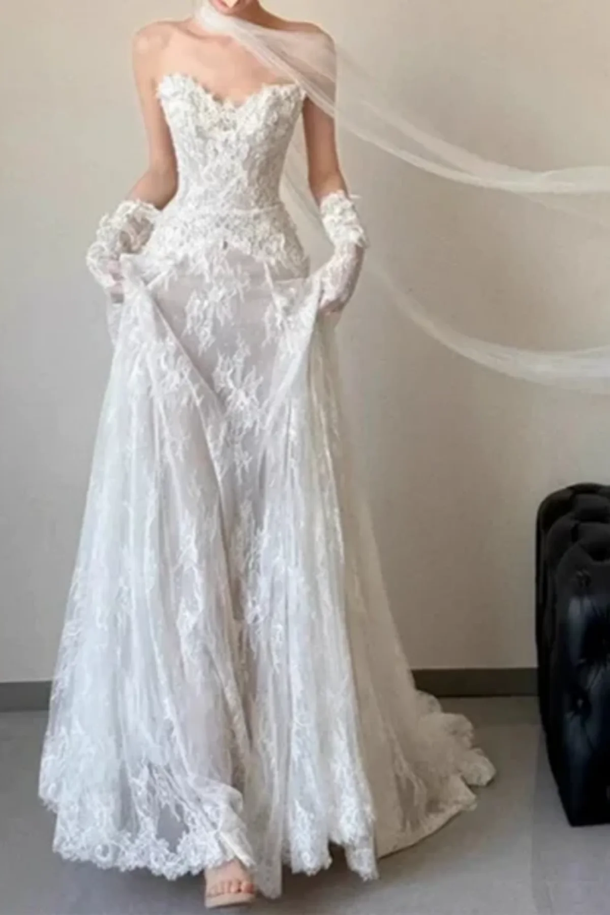 Front view of a model twirling in a lightweight floral lace bridal gown, showing off the dramatic movement of the flared skirt