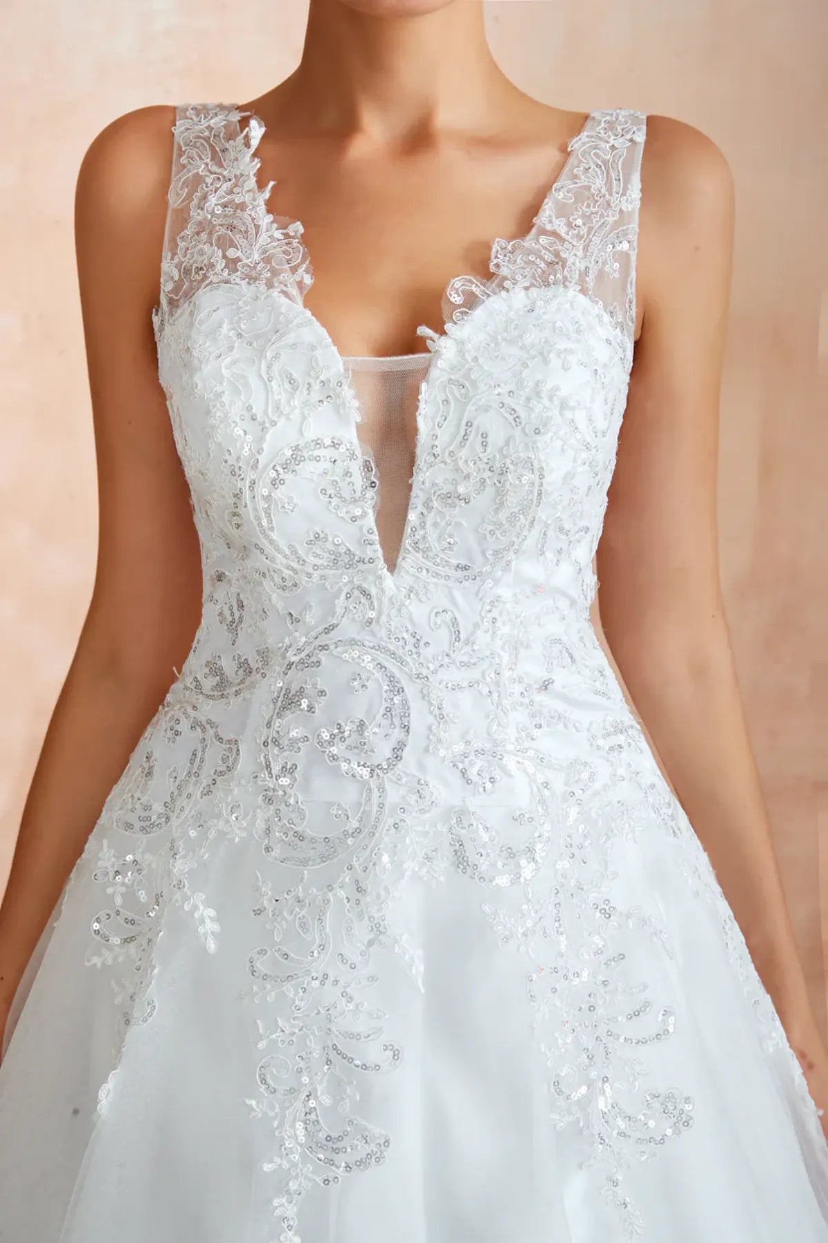 sequined white wedding dress with plunging sheer v-neck and wide straps