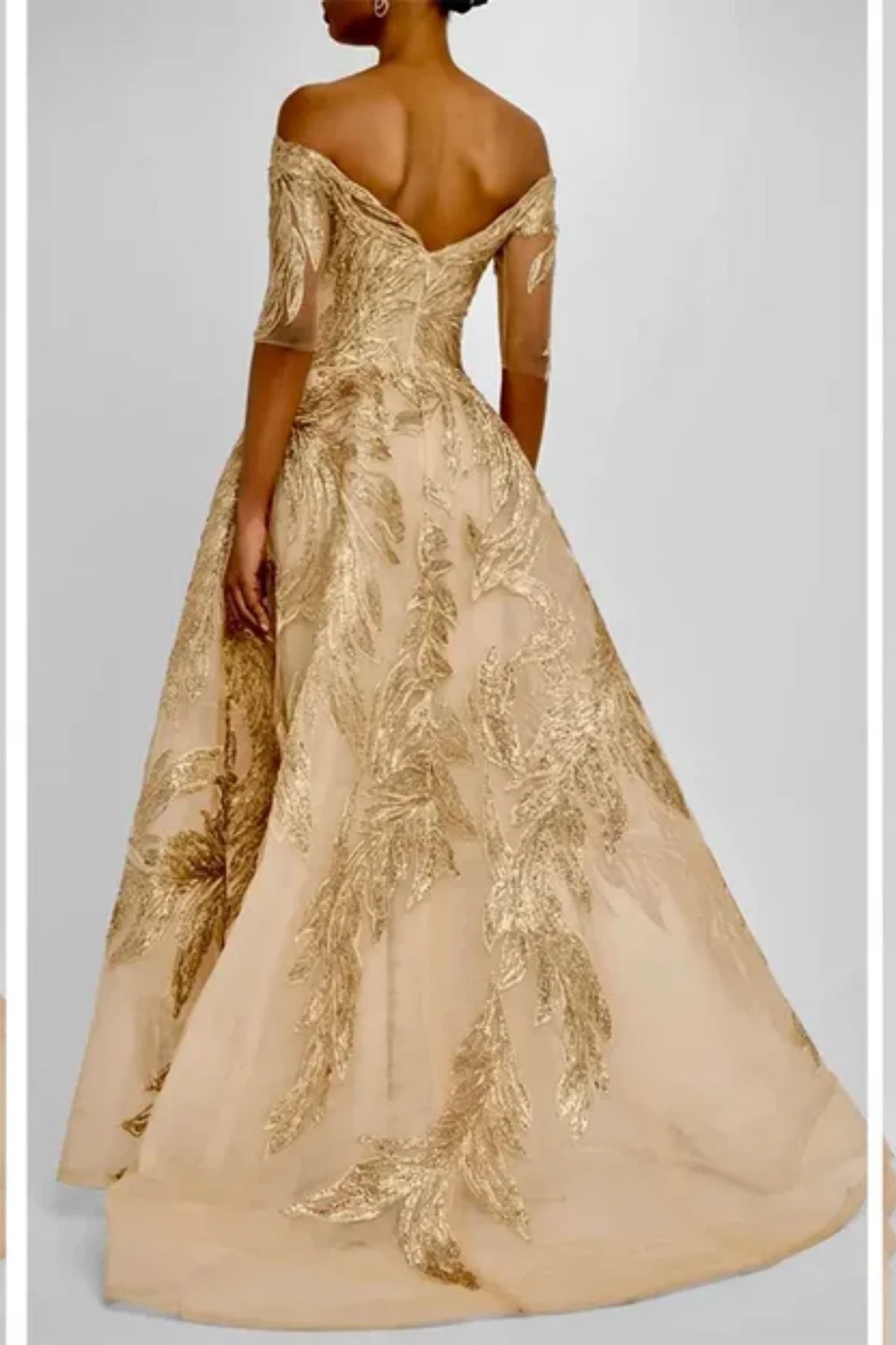 Full back view of a gold A-line formal evening gown on a mannequin, showing a high zipped back, tailored shoulder straps, and a sweeping floor-length skirt covered in metallic gold embroidery