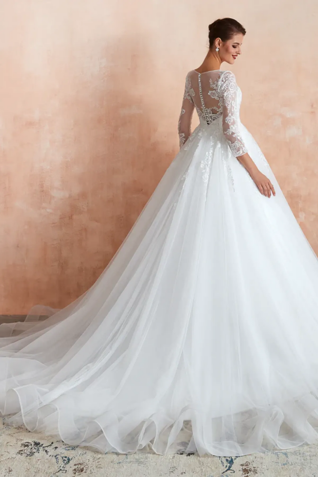 Ball gown wedding dress with sheer lace back, long sleeves, and chapel-length tulle train