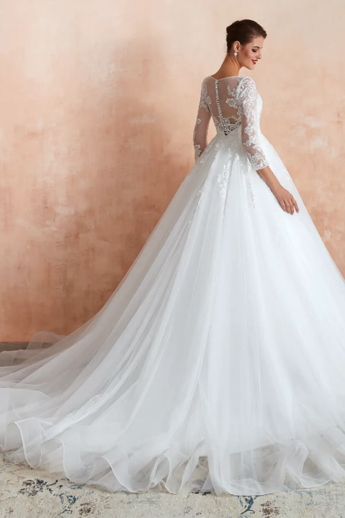 Ball gown wedding dress with sheer lace back, long sleeves, and chapel-length tulle train