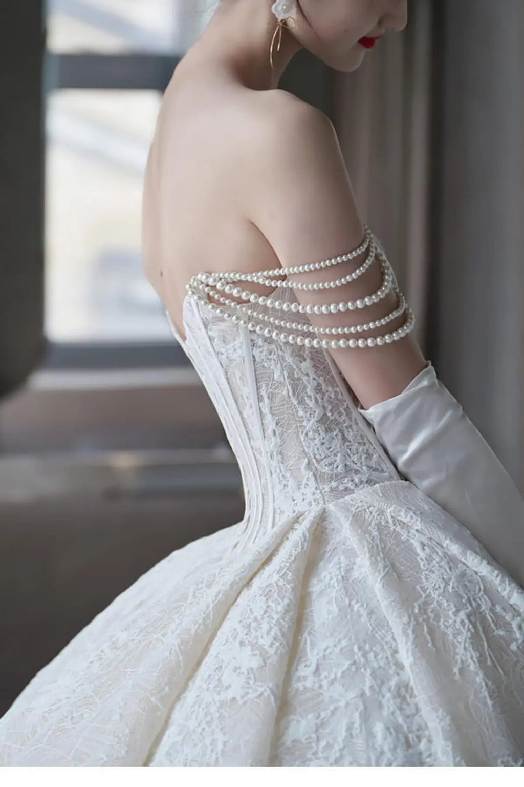 a champagne A-line bridal gown on a model, showing the layered tulle skirt decorated with intricate wildflower embroidery