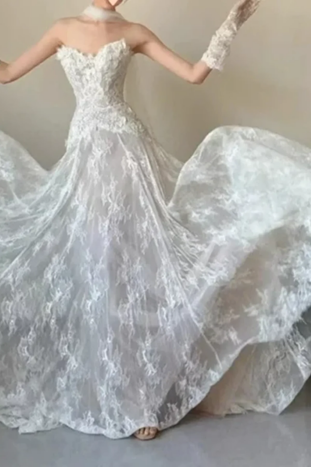 Full-length front view of an ivory floral lace wedding dress with a subtle champagne underlay, featuring textured 3D lace details on the sweetheart bodice