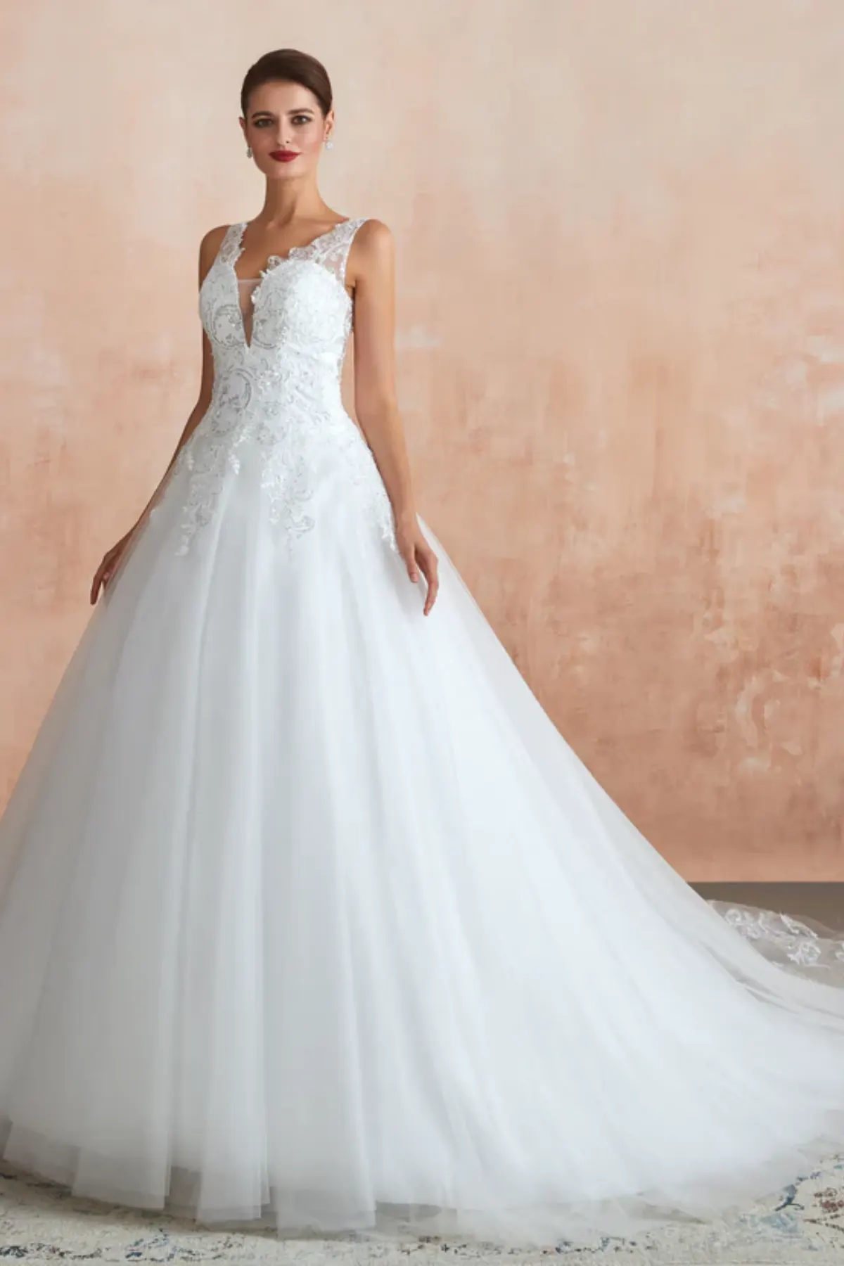 Lace applique bridal gown with soft tulle skirt and cathedral train elegant angled front view