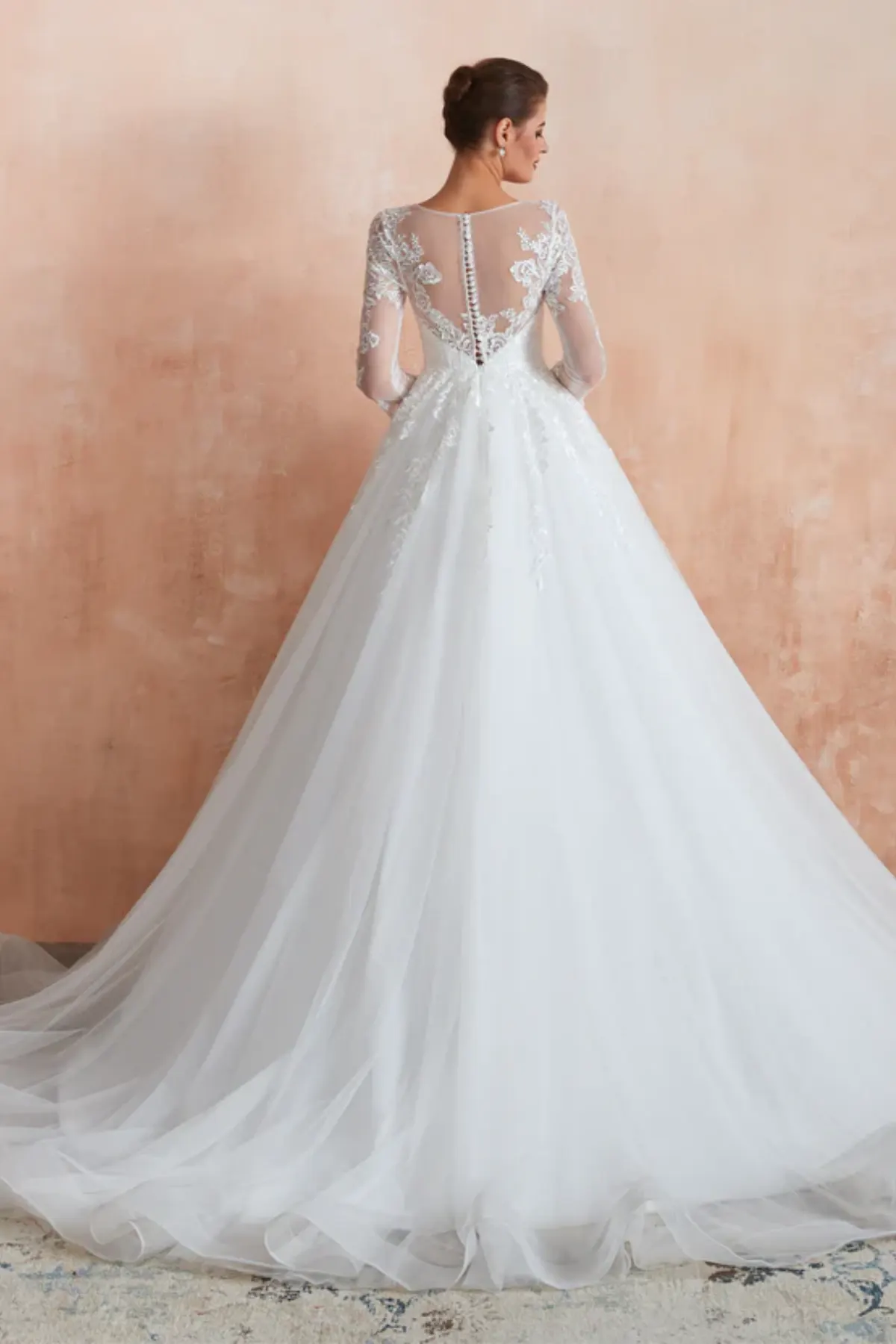 Ball gown wedding dress with sheer lace back, long sleeves, and chapel-length tulle train