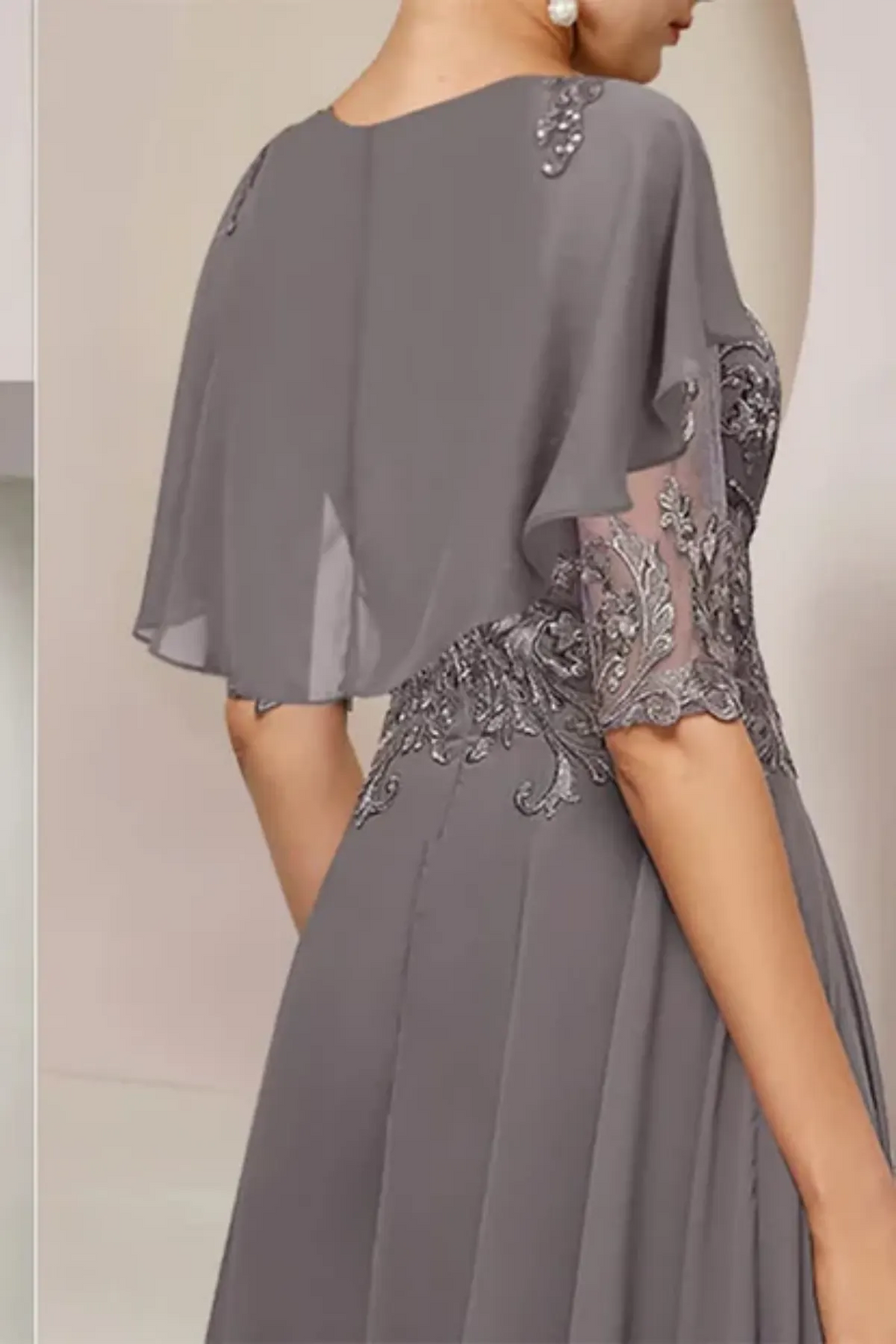 Close-up of a champagne formal dress bodice, showcasing the textured 3D-effect floral lace patterns detailing the sheer overlay