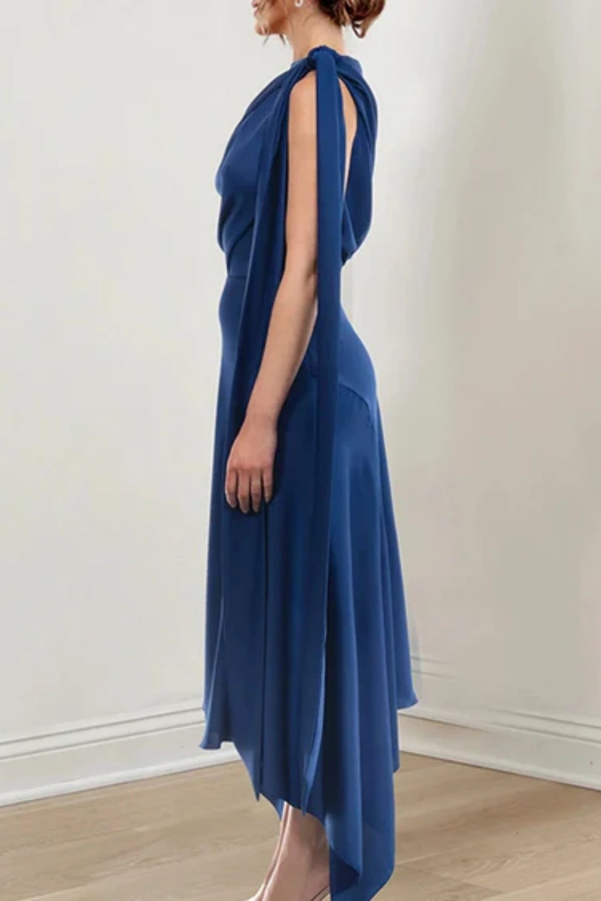 Close-up of the front of a navy blue wedding dress for mothers, highlighting the detailed bodice ruching and a matching chiffon tie-up at the shoulder