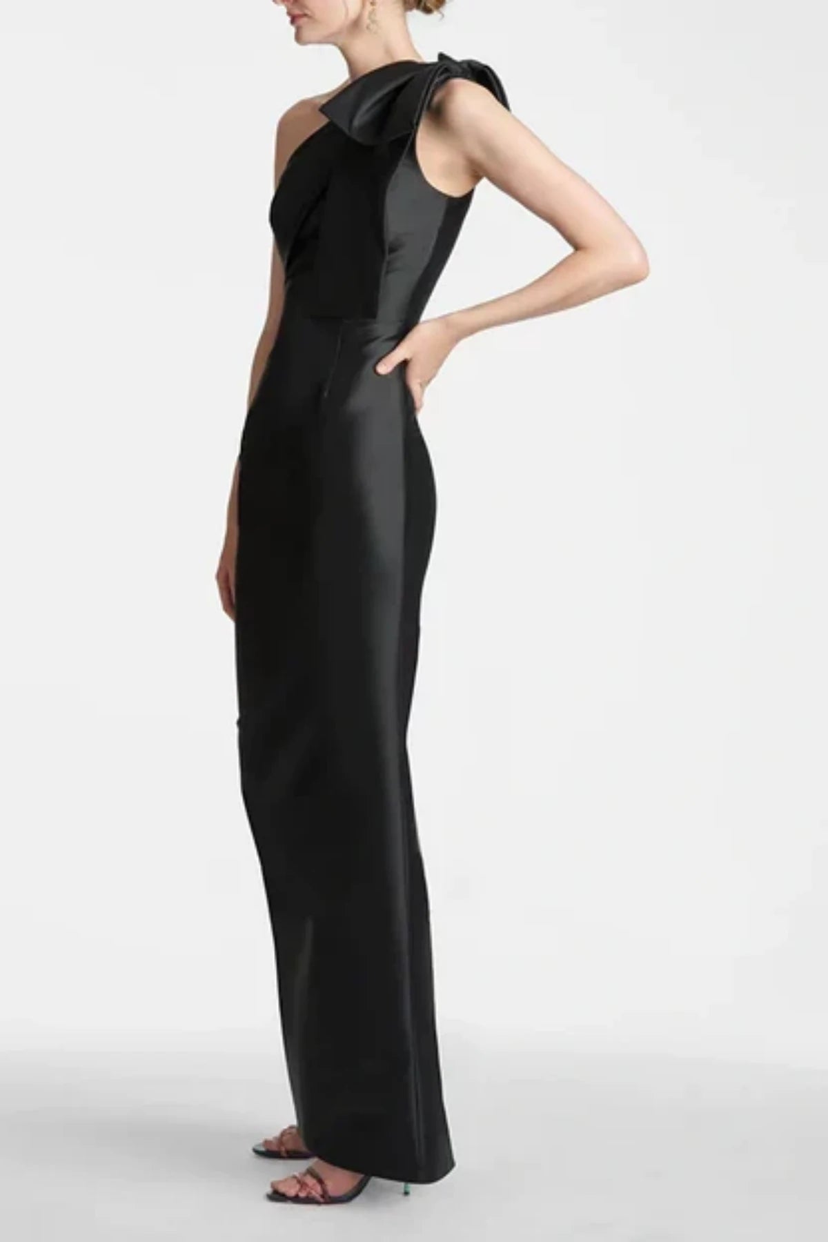 Close-up of the bodice on a black sheath mother of the bride dress, highlighting the asymmetric neckline and three structured satin bows along the shoulder strap
