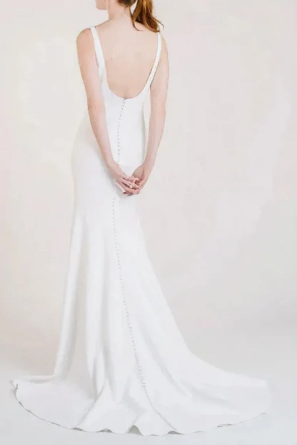 Minimalist bridal gown featuring low scoop back and buttons
