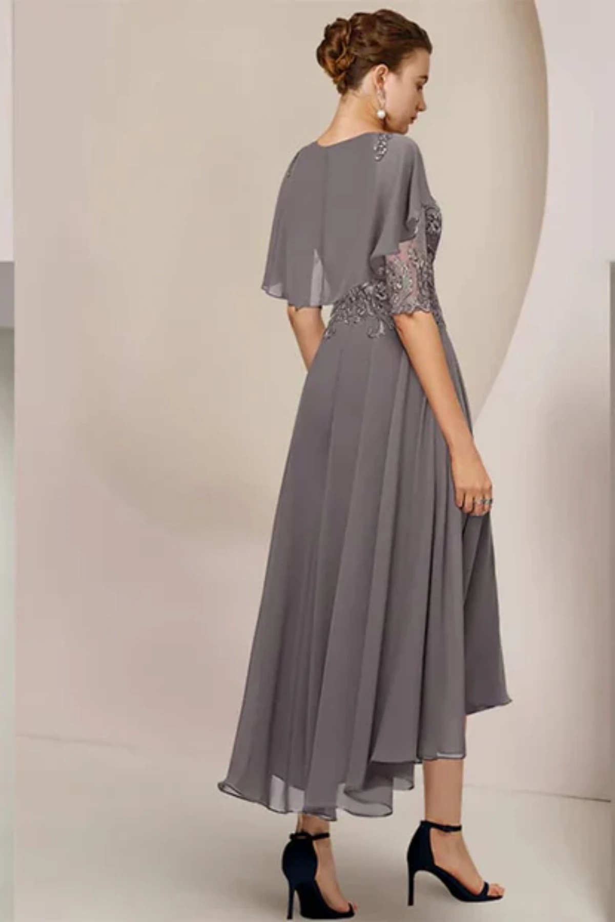 A regal slate grey fit-and-flare evening gown designed with an integrated sheer capelet for sophisticated coverage