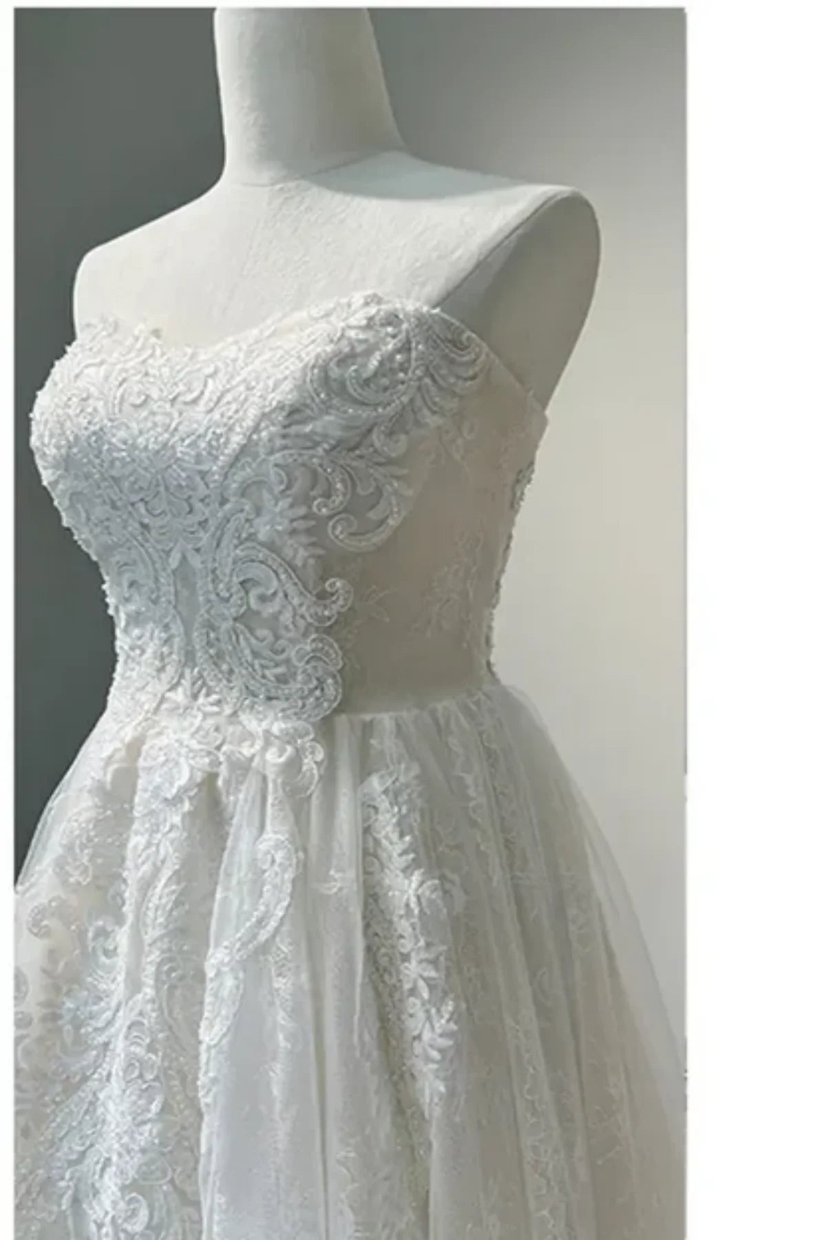 Detailed lace sweetheart bodice of strapless convertible wedding dress with floral embroidery