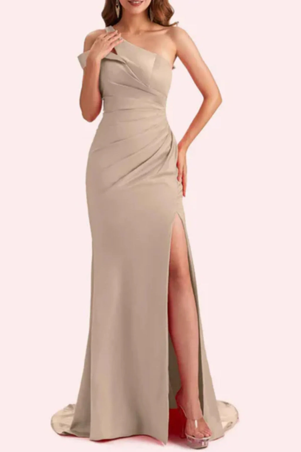 Full front view of a taupe satin mother of the bride dress displaying heavy asymmetric ruching, a fitted column-mermaid silhouette, and a high front slit on a mannequin