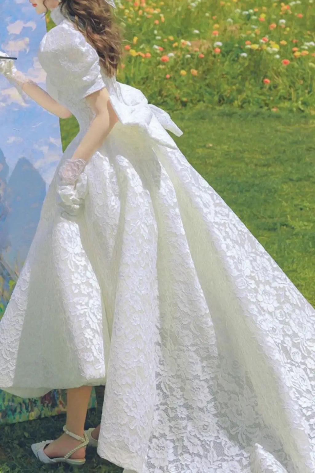 Vintage lace tea-length wedding dress with puff sleeves in a romantic garden painting scene