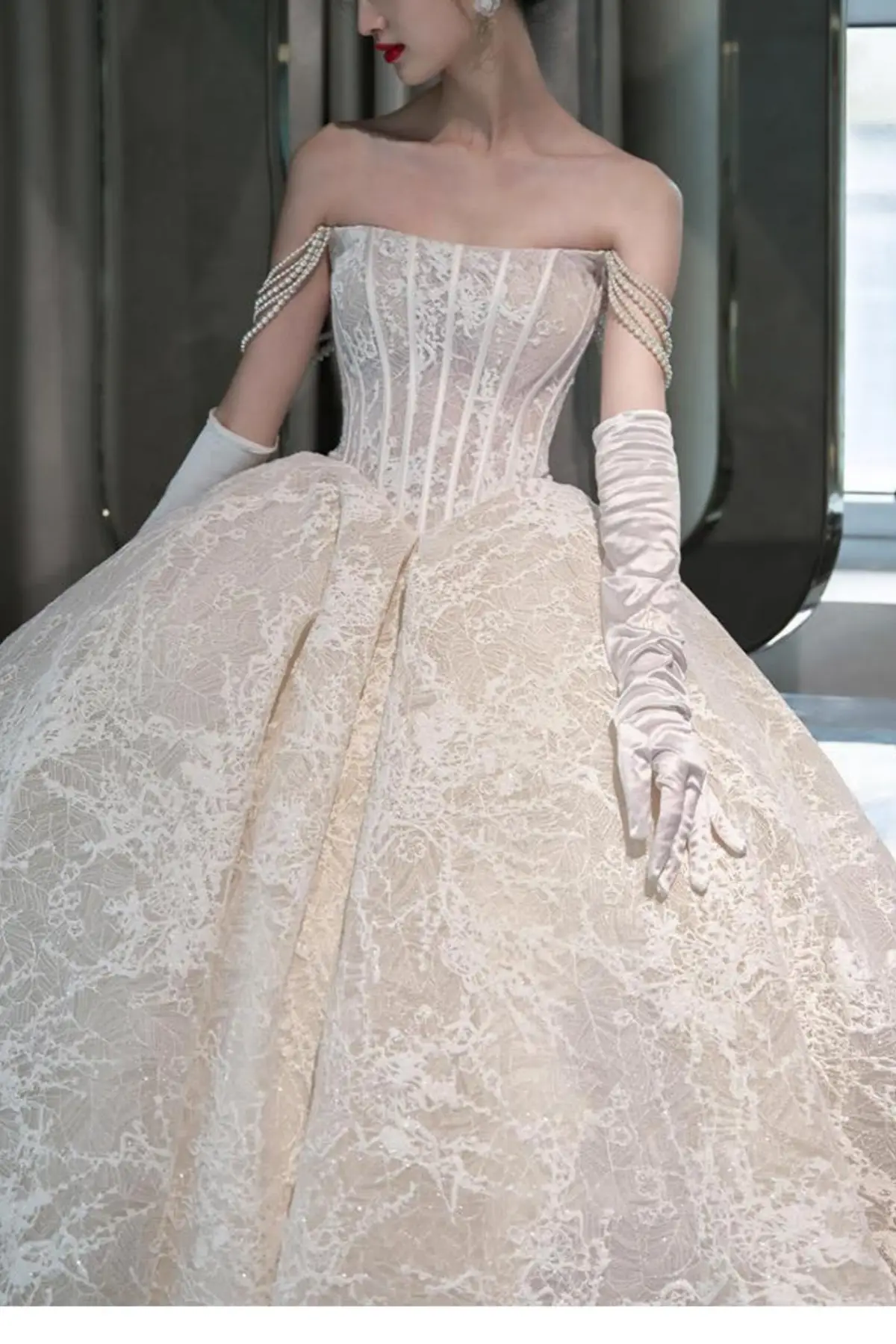 Front close-up of a champagne bridal gown showcasing a structured corset bodice with exposed boning and basque waist details