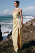 Champagne yellow satin bridesmaid dress with draped bodice, spaghetti straps, and high front slit